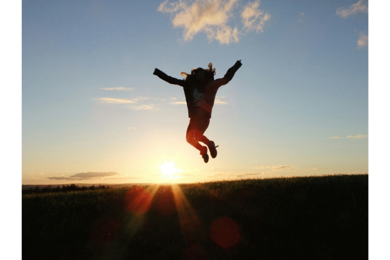 Person jumping joyfully at sunrise, symbolizing hope and the desire to grow spiritually.